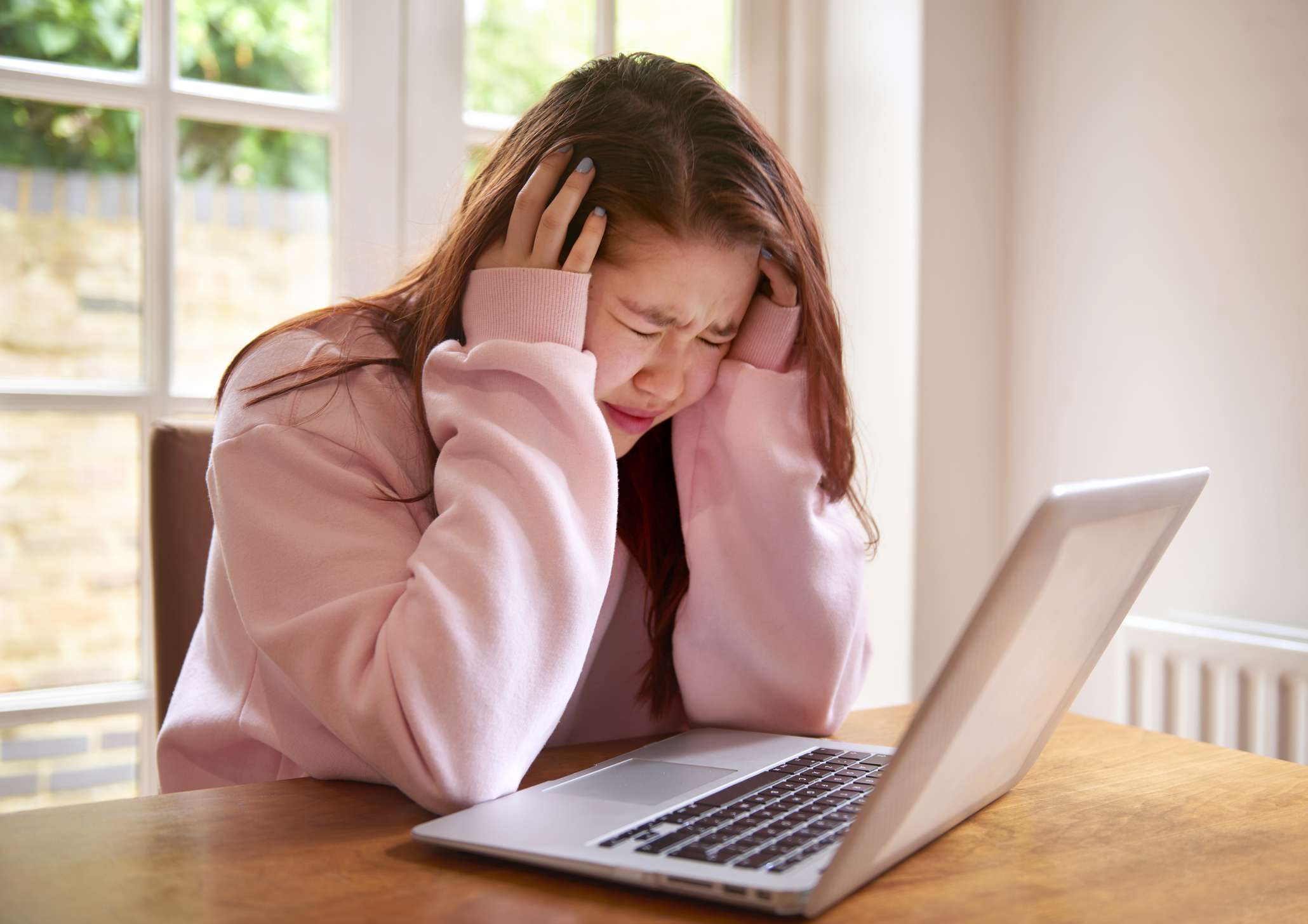 Teenager crying using laptop - stock photo